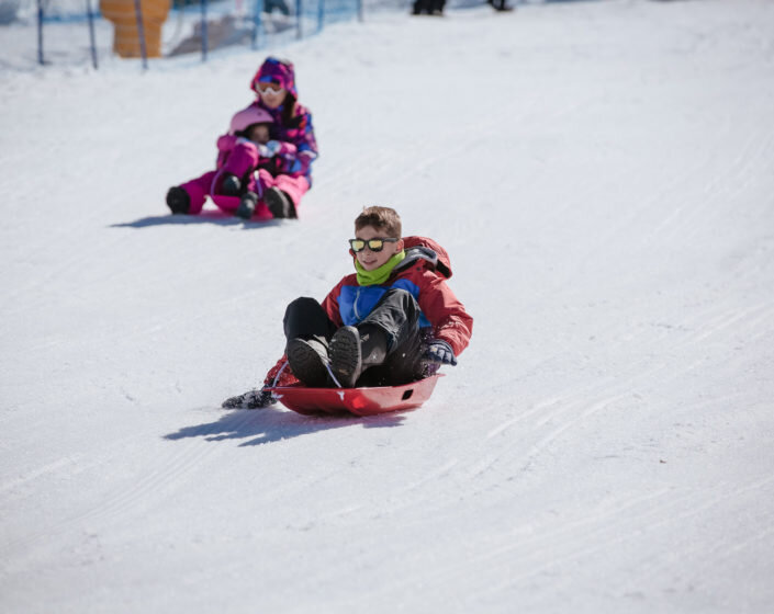 A kid is snow sledding in Lake Mountain